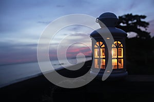 Lantern with candle light inside in the night after sunset on the beach