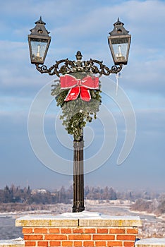 Lantern with Christmas decoration on a sunny winter day on old brick bridge in Kuldiga, Latvia