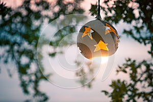 Lantern from the coconut tree with lamp on the background of sunset on the beach