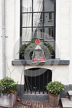 Lantern in front of a window of a house during Christmas