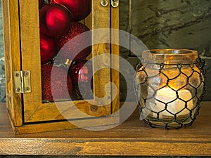 Lantern full of Christmas balls next to illuminated lantern