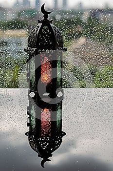 Lantern that have moon symbol on top put on window with rain drop