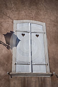 Lantern and its shadow on a wall. White shutters with a hearts. Details. Colmar, France photo