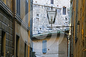 lantern between medieval houses on street in Siena