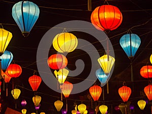 Lantern seller in the streets of ancient town of Hoi An in Central Vietnam, colorful lanterns hanging everywhere creating a great