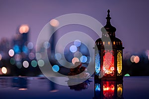 Lantern and small plate of dates fruit with night sky and city bokeh light background