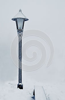 Lantern standing in fog and snow