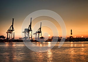 Genova Porto Antico harbor view with cranes and Lanterna landmark photo