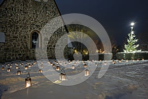 lanterns and a Christmas tree in a church cemetery in the small Finnish town of Pernio