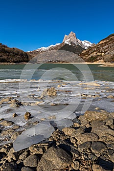 Lanuza reservoir (Huesca), frozen water and first snow in the mountains