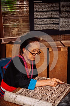 Laotian Senior woman do Batik fabric painting