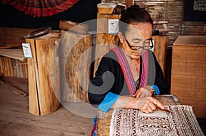 Laotian Senior woman do Batik fabric painting