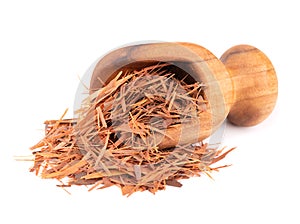 Lapacho herbal tea in wooden scoop, isolated on white background. Natural Taheeboo dry tea. Pau d'arco herb. Tabebuia photo