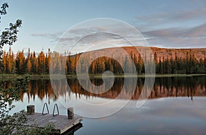 Lapland mountain reflecting on lake on midsummer evening