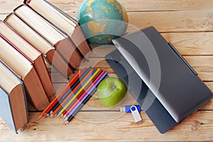 laptop, apple and many books on wooden background