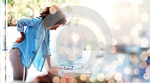 Laptop, backache and posture with a business woman holding her spine in pain at the office for work. Computer, space and