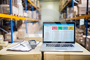 Laptop and barcode scanner on boxes in a warehouse. photo