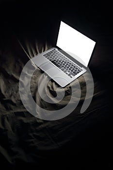 Laptop in bed. Night working at home concept image with copyspace