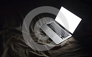 Laptop in bed. Night working at home concept image with copyspace