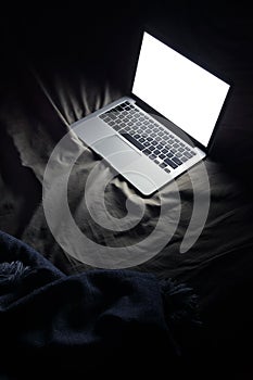 Laptop in bed. Night working at home concept image with copyspace