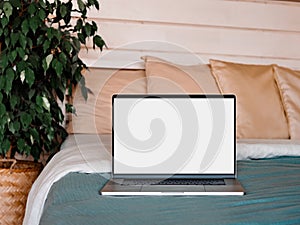 Laptop blank screen on bed in country house, mockup, template photo