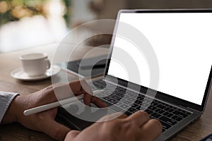 Laptop with blank screen on table interior, man at his workplace using