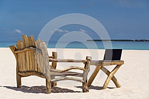 Laptop blank screen on wooden desk with beach. relax concept.