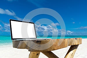 Laptop blank screen on wooden desk with beach. relax concept.