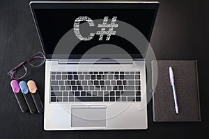 Laptop with C# text. Top view. C sharp inscription on laptop screen