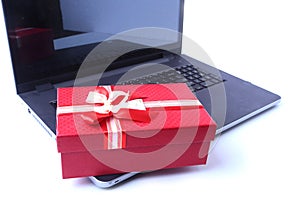 Laptop and christmas gifts box on white desk