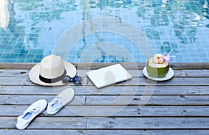 Laptop and coconut drink by awimming pool