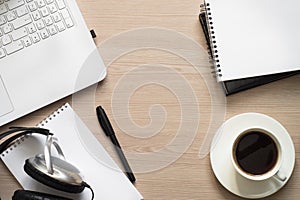 Laptop, coffee and croissant at desk table.