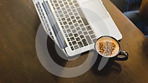 Laptop and coffee cup at his working place in Cafe