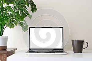 Laptop computer with blank screen for mockup on modern contemporary workspace desk with coffee cup and office supplies. Home