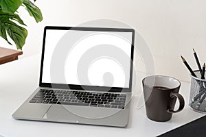 Laptop computer with blank screen for mockup on modern contemporary workspace desk with coffee cup and office supplies. Home