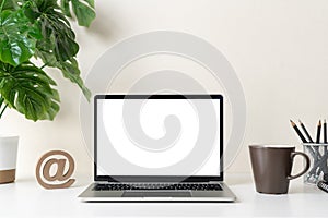 Laptop computer with blank screen for mockup on modern contemporary workspace desk with coffee cup and office supplies. Home