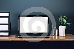 Laptop computer with blank screen on office desktop