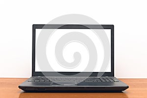 Laptop computer with blank white screen on the desk table.