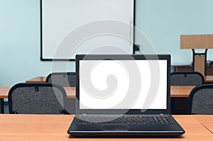 Laptop computer with blank white screen on the desk table.