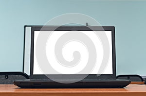 Laptop computer with blank white screen on the desk table.