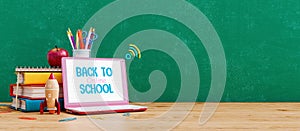 Laptop computer with books and school accessory. Back to online school concept background