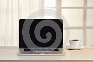 Laptop computer with coffee cup