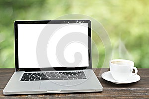 Laptop computer with coffee cup on wooden with defocus of garde