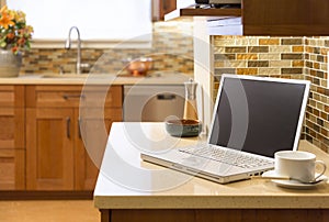 Laptop computer on counter in contemporary upscale home kitchen