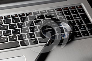 Laptop computer with magnifying glass on blue background, concept of search. Internet security conceptual image