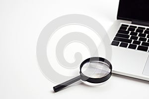 Laptop computer with magnifying glass. Work and search concept.