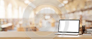 A laptop computer mockup on a wooden desk with a blurred background of a beautiful spacious library