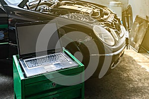 Laptop or computer notebook interfaced with car for repair during work investigate cause of problem program and electric system