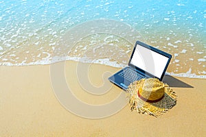 laptop or computer notebook on sea beach and wave - business travel background with empty white screen clipping path