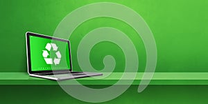 Laptop computer on a shelf with a recycling symbol on screen. environmental conservation concept